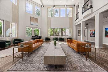 A spacious living room with a long wooden table in the center and multiple seating options.